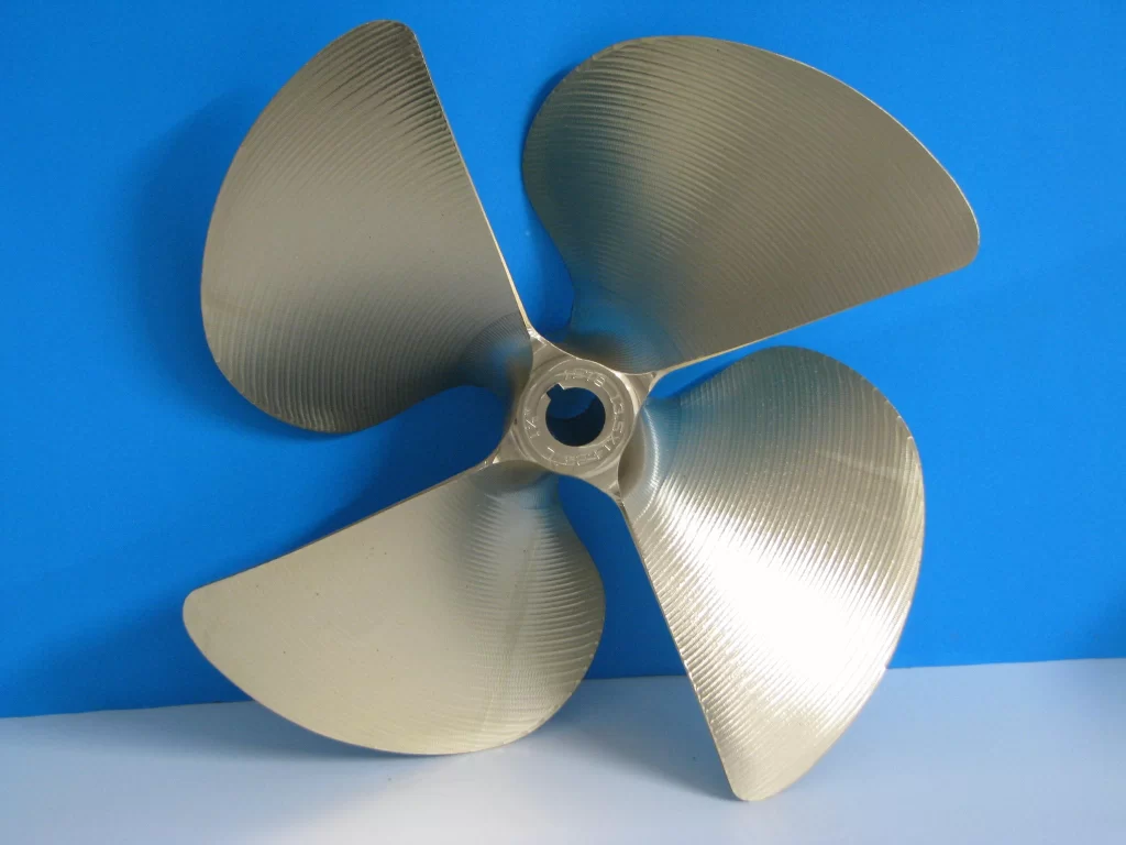 A shiny, three-blade metal propeller against a blue background showcases its curved blades and central hub.