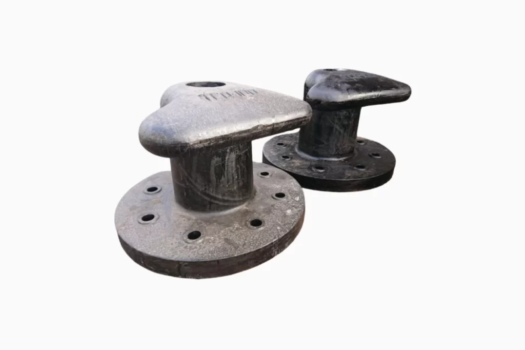 Two metal mooring cleats, one light grey and one dark grey, with circular bases featuring holes for secure installation.