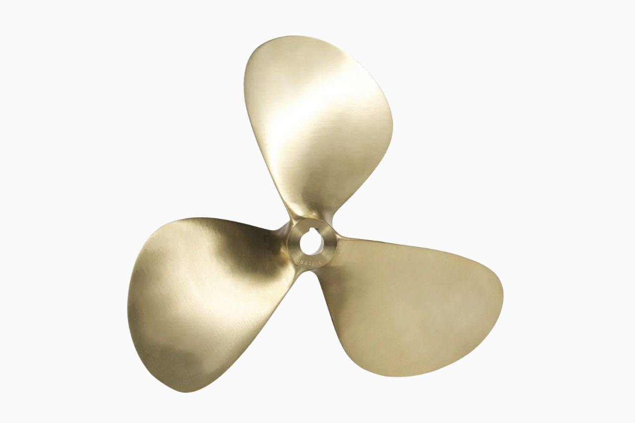 Gold-finished propeller against a clean white background, showcasing its sleek design and polished surface.