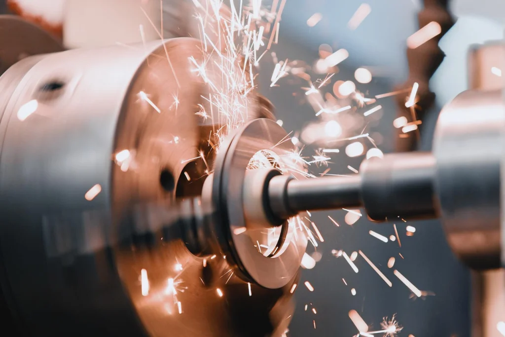 Close-up of a metalworking machine in action at a precision casting company, with bright sparks flying as it cuts through metal, showcasing industrial power and craftsmanship.